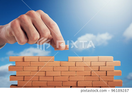 Businessman puts a brick to build a wall. Concept of new business, partnership, integration and startup 96189287