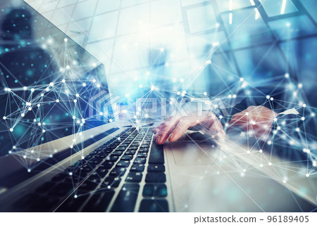 Business man works in office with laptop in the foreground. Concept of teamwork and partnership. double exposure with network effects Business man works in office with laptop in the foreground. Concept of teamwork and partnership. double exposure with network effects 96189405