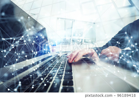 Business man works in office with laptop in the foreground. Concept of teamwork and partnership. double exposure with network effects 96189418