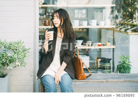 Woman drinking coffee outdoors 96189895