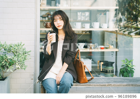 Woman drinking coffee outdoors 96189896