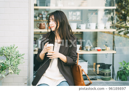 Woman drinking coffee outdoors 96189897