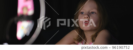 Girl child shoots video on tripod in dark 96190752