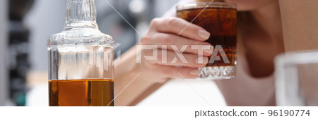 Drunk depressed alcoholic woman drinking whiskey alone at home Drunk depressed alcoholic woman drinking whiskey alone at home 96190774