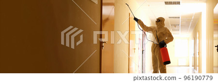 Person wearing white chemical protection suit holding spray bottle with disinfectant chemicals Person wearing white chemical protection suit holding spray bottle with disinfectant chemicals 96190779