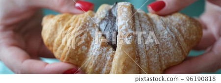 Cropped view of woman holding fresh croissant with chocolate Cropped view of woman holding fresh croissant with chocolate 96190818