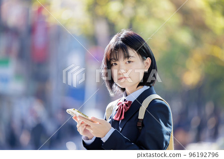 High school girl watching smartphone 96192796