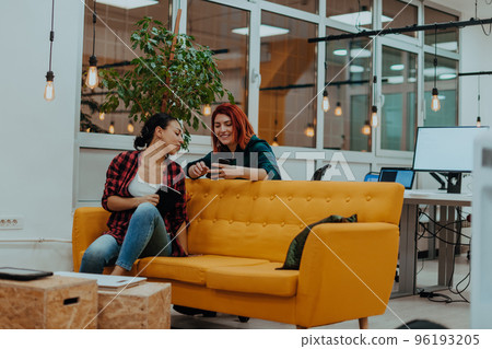 group of female friends having a team meeting and discussion about project or gossip chatting in modern startup business office 96193205