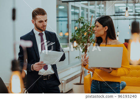 The boss of the company talking to his employee while she shows him the final report on the laptop The boss of the company talking to his employee while she shows him the final report on the laptop 96193240