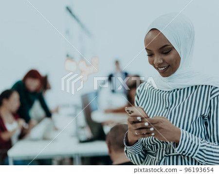 Young African American businesswoman talking on a smartphone in a modern startup office. Marketing concept. Multi-ethnic society. Young African American businesswoman talking on a smartphone in a modern startup office. Marketing concept. Multi-ethnic society. 96193654