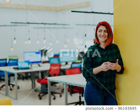 Headshot portrait of modern woman in office at night near window using smartphone Headshot portrait of modern woman in office at night near window using smartphone 96193695