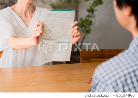 A middle-aged woman presenting a divorce notice to a middle-aged man Image of a middle-aged divorce 96194966