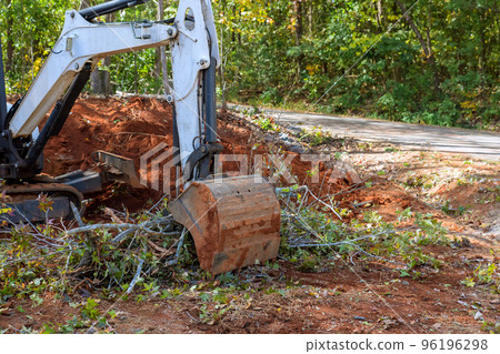 Tractor skid steer was used to clear trees roots for building of subdivision on piece land cleared during landscaping works. 96196298