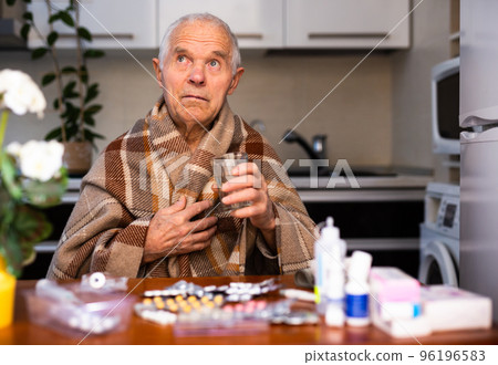 old man with many medical pills and capsules in hands 96196583