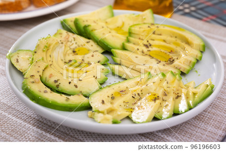 ripe avocado pulp cut into pieces sprinkled with lemon juice on a plate 96196603