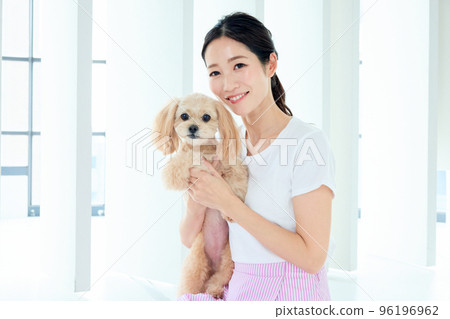 A woman who plays with a dog 96196962