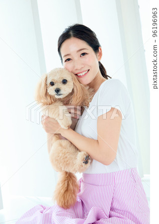 A woman who plays with a dog 96196963