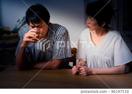 A middle man with his head down at home and a middle woman comforting him 96197538