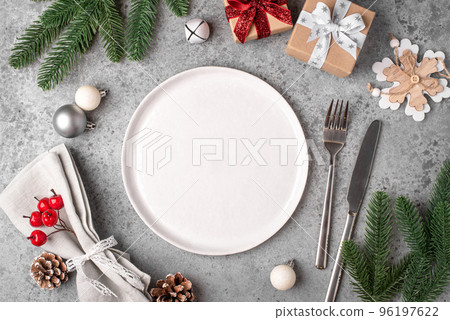 Christmas place setting and decorations on gray table. 96197622
