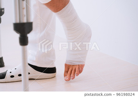 Middle-aged man walking with crutches Rehabilitation image 96198024