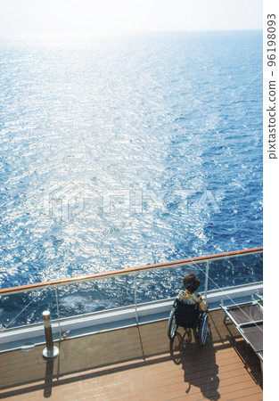 Disabled woman in a wheelchair on the deck of a cruise ship looking at the bright sunlight, the concept of travel accessibility for disabled Disabled woman in a wheelchair on the deck of a cruise ship looking at the bright sunlight, the concept of travel accessibility for disabled 96198093
