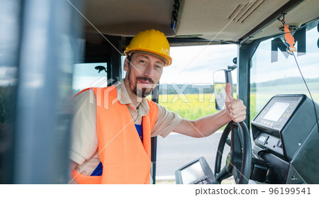 Construction worker on excavator planning the work to be done Construction worker on excavator planning the work to be done 96199541