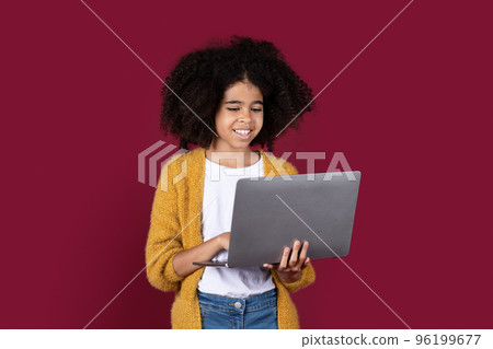 Adorable black girl schooler using modern computer Adorable black girl schooler using modern computer 96199677
