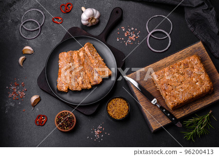 Tasty meat brawn or roll on a wooden cutting board with spices and herbs Tasty meat brawn or roll on a wooden cutting board with spices and herbs 96200413