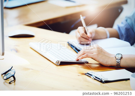 Young economists or accountants or financiers and investors are reviewing using computer and notebook to study impact and risk assessments on corporate investment management 96201253