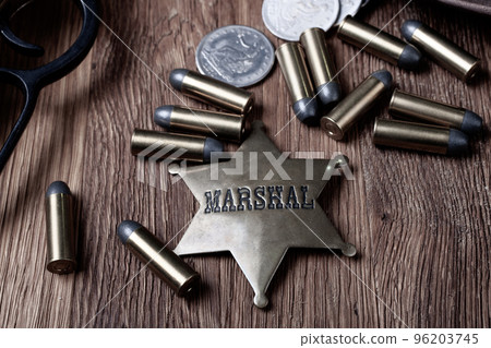 Old west marshal badge with rifle, silver dollar coin and ammunition Old west marshal badge with rifle, silver dollar coin and ammunition 96203745