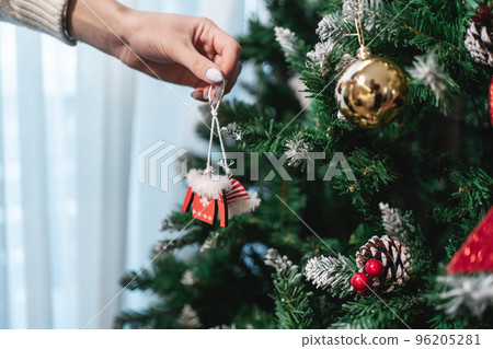 person decorating christmas tree with toys at new year eve person decorating christmas tree with toys at new year eve 96205281