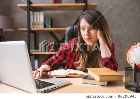 Woman teleworker works at home with a laptop with a lot of questions. She is in smart working due to covid-19 pandemic Woman teleworker works at home with a laptop with a lot of questions. She is in smart working due to covid-19 pandemic 96206943