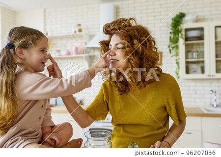 Mother and daughter prepare a cake together in the kitchen Mother and daughter prepare a cake together in the kitchen 96207036