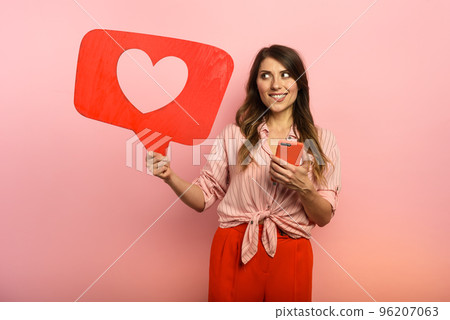 Woman is happy because receives hearts on social network. Pink background Woman is happy because receives hearts on social network. Pink background 96207063