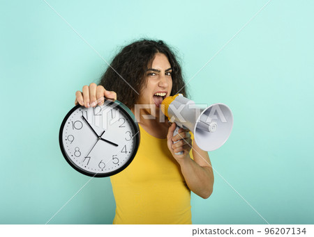 Woman screams with loudspeaker because is too late. angry expression. cyan background Woman screams with loudspeaker because is too late. angry expression. cyan background 96207134