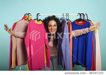 Woman chooses the clothes to buy in a store. Concept of shopping and shopaholic. Woman chooses the clothes to buy in a store. Concept of shopping and shopaholic. 96207143