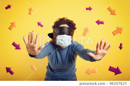Woman with mask and blindfold has difficulty to find the right way. concept of uncertainty. yellow background Woman with mask and blindfold has difficulty to find the right way. concept of uncertainty. yellow background 96207625