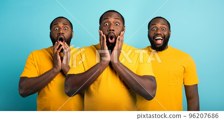 Black man with wondered, surprised and happy expression on cyan background 96207686