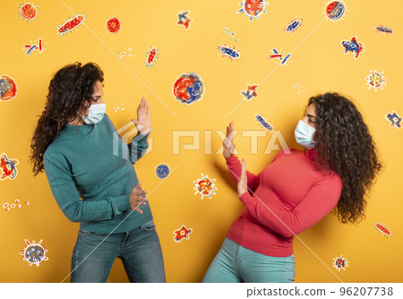 Friends stay away to avoid contact and contagion of the virus. Concept of codiv-19 rules to avoid pandemic. yellow background 96207738