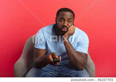 Man is annoyed because there are nothing of interesting to see on television 96207765