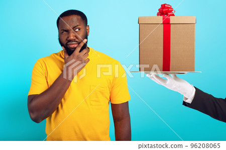 Confused man is suspicious about a gift. concept of options, confusion, indecision Confused man is suspicious about a gift. concept of options, confusion, indecision 96208065