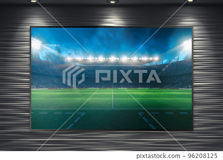 Watching a soccer event on a large TV wall mounted and illuminated by spotlights 96208125