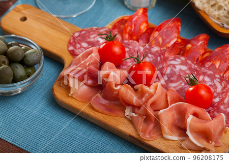 Spanish tasty meal slicing sausages and jamon with tomatoes, close up Spanish tasty meal slicing sausages and jamon with tomatoes, close up 96208175