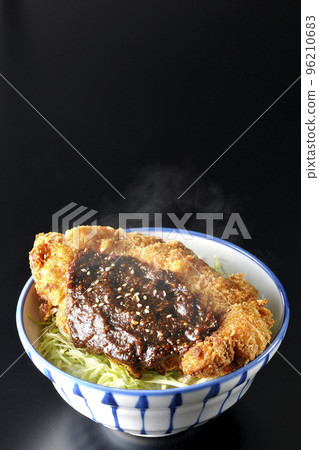 一個熱味噌肉排碗,裡面有很多捲心菜,在黑色背景下拍照 一個熱味噌肉排碗,裡面有很多捲心菜,在黑色背景下拍照 96210683