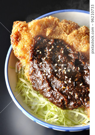 A bird's-eye view of a piping hot miso katsudon with plenty of cabbage on a black background 96210733