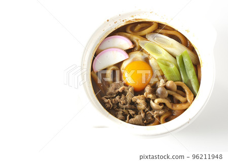 Miso-nikomi udon with beef, shimeji mushrooms, green onions, kamaboko, and egg yolk is photographed from above with a white background. Miso-nikomi udon with beef, shimeji mushrooms, green onions, kamaboko, and egg yolk is photographed from above with a white background. 96211948