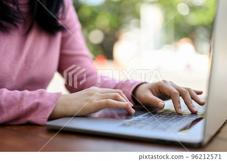 Asian female freelancer remote working at the cafe, using laptop, sitting outside or the cafe. Asian female freelancer remote working at the cafe, using laptop, sitting outside or the cafe. 96212571