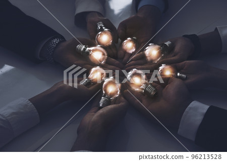 Teamwork and brainstorming concept with businessmen that share an idea with a lamp. Concept of startup 96213528