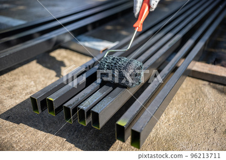 Worker painting steel post in construction site. Worker painting steel post in construction site. 96213711