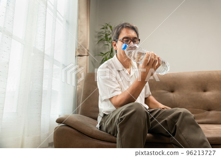 Senior asian man workout water bottle at home to preserve his muscle mass, prevent sarcopenia and bone resorption. 96213727